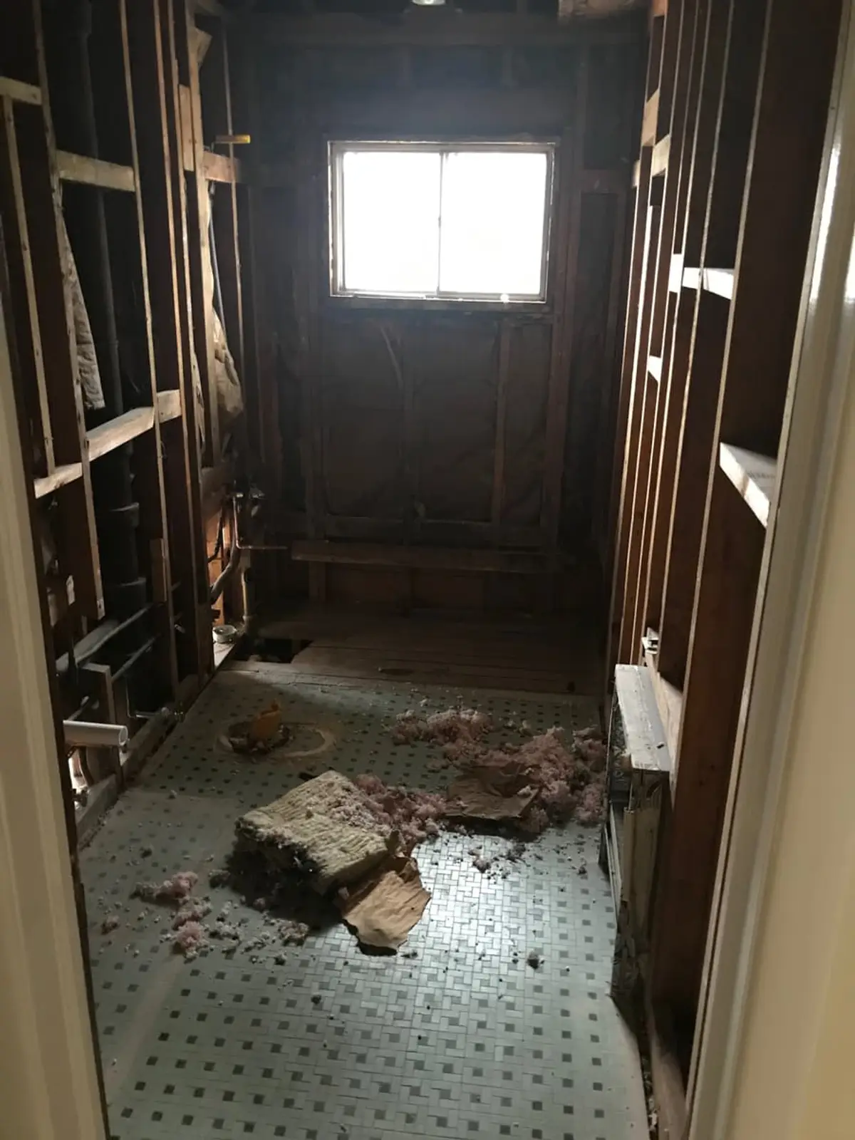 Selling a house with unpermitted work in Plainview: bathroom stripped to the studs with debris on the tile floor