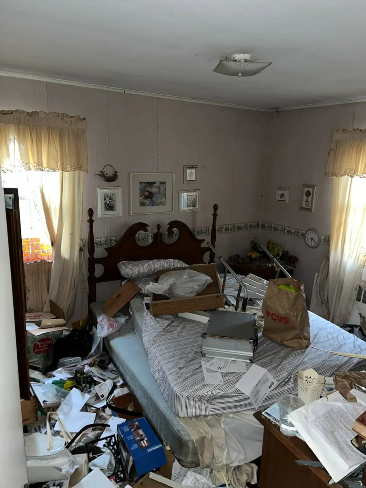 Selling a hoarder house in Plainview: bedroom buried in papers, boxes and belongings
