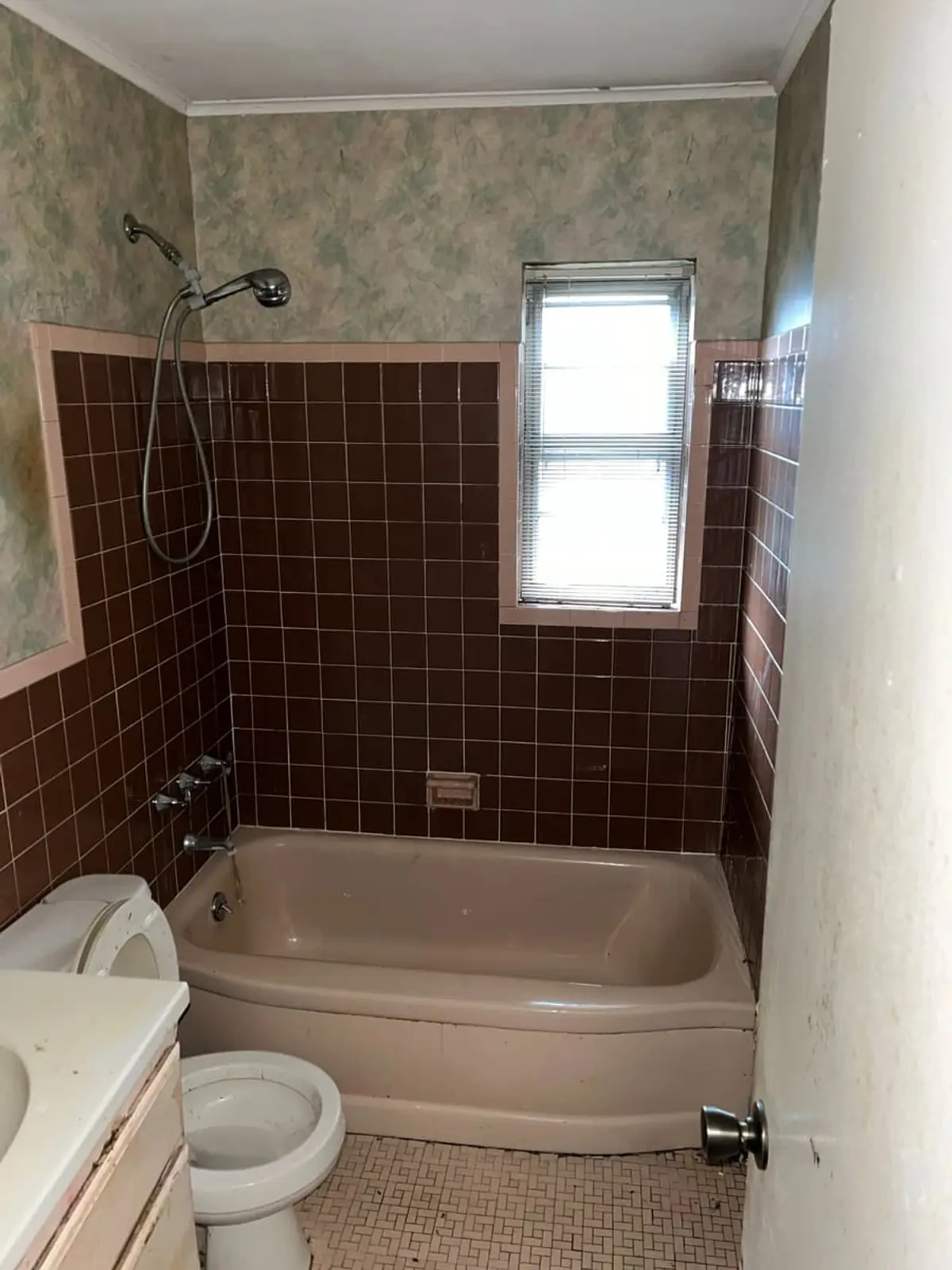 Selling a house in probate in Plainview: dated bathroom with brown tile and a pink tub
