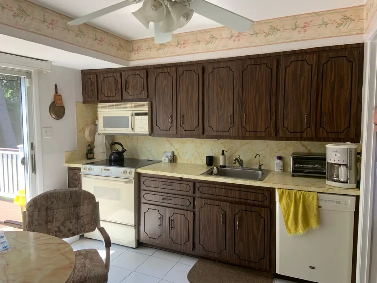 Selling estate property as an executor in Plainview: dated kitchen with dark wood cabinets and a floral border