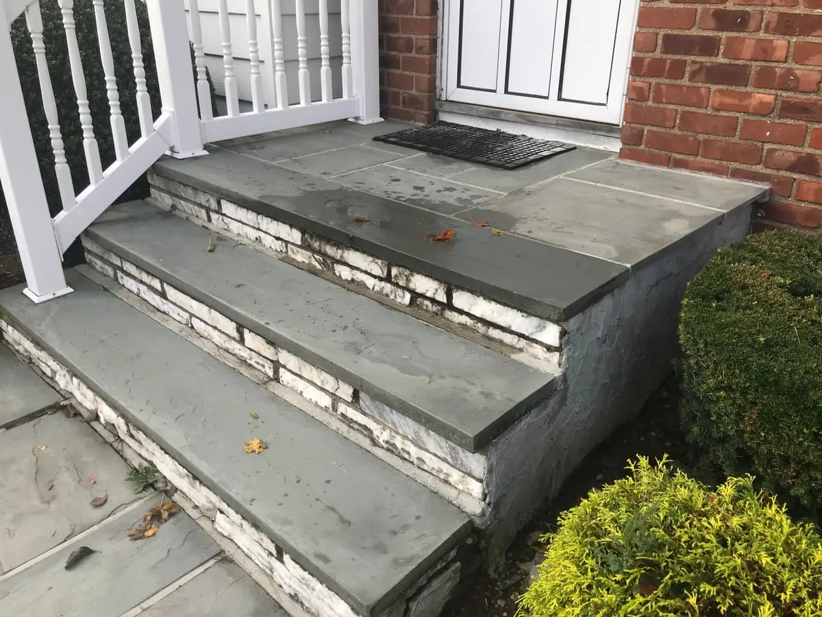Selling a house in pre-foreclosure in Plainview: front steps with cracked bluestone and crumbling mortar