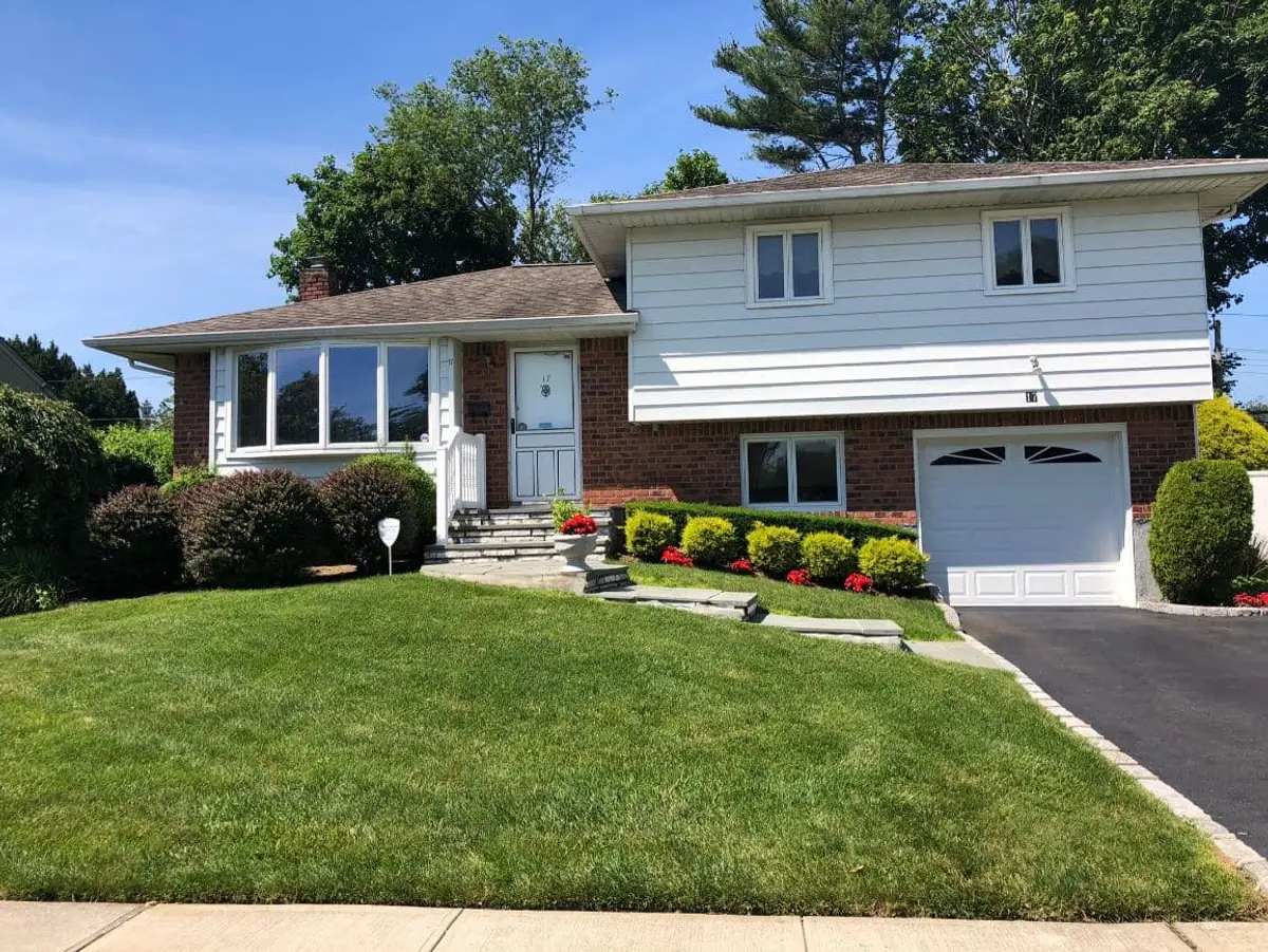 Selling a house held in a trust in Plainview: split-level with a brick lower story and an attached garage
