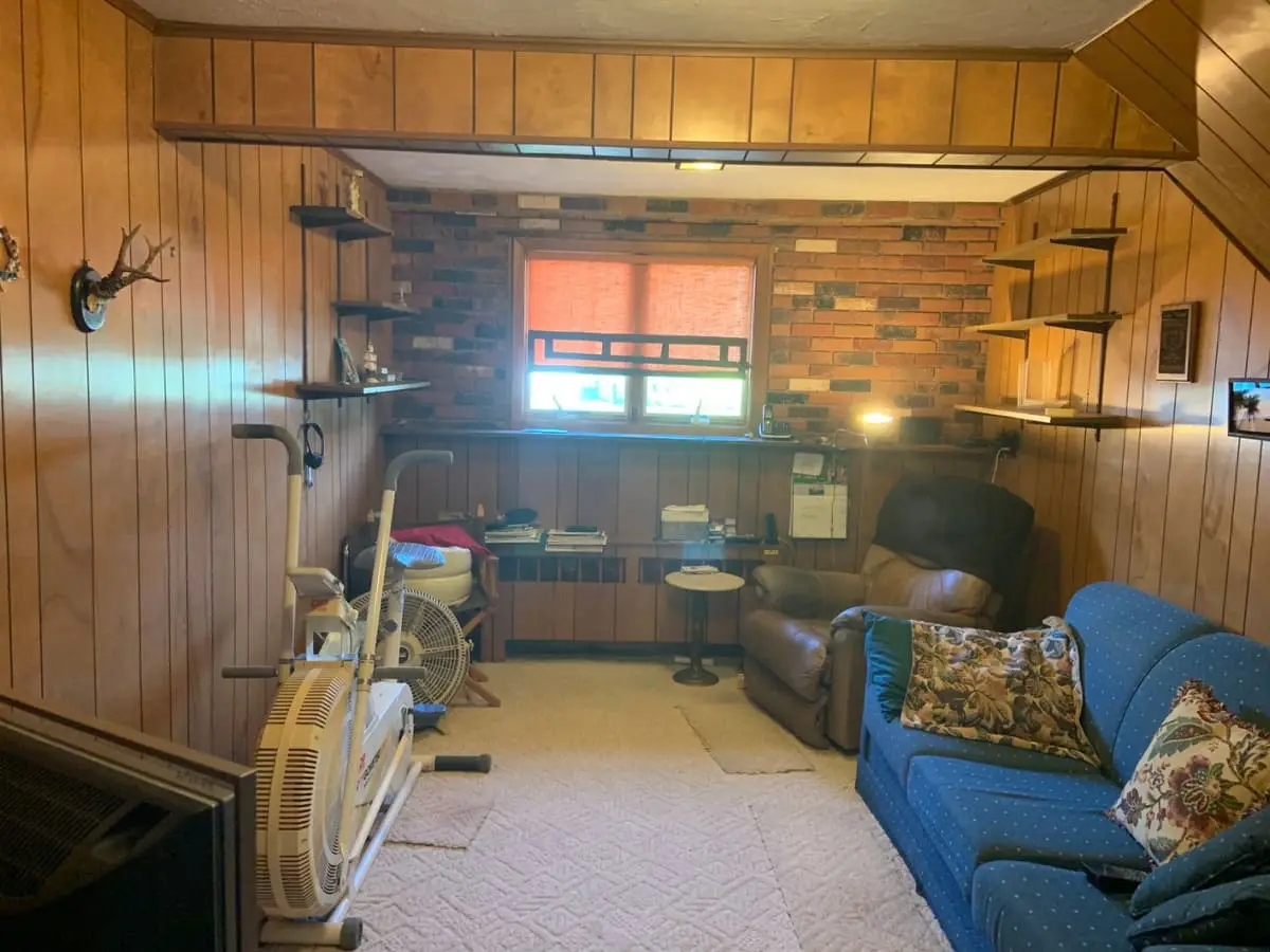 Downsizing or retiring in Plainview: wood-paneled den with a brick accent wall